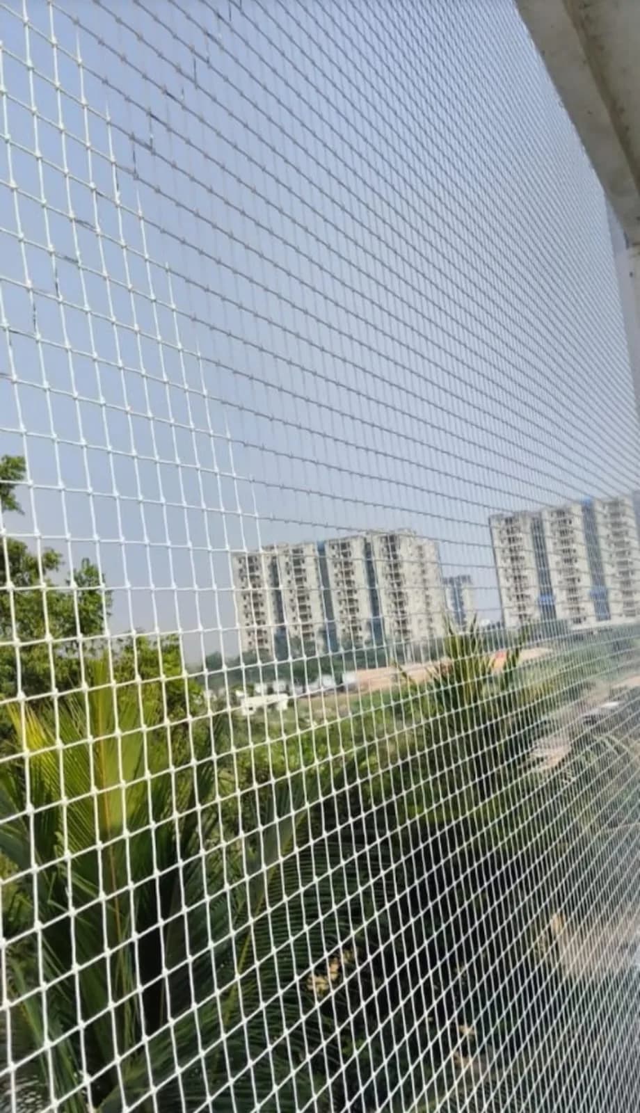 Balcony safety net installed across an apartment balcony at night